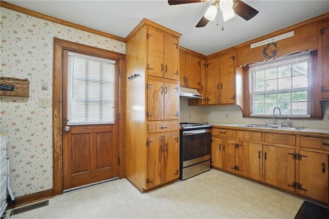 kitchen with a sink, stainless steel electric stove, ceiling fan, light countertops, and light floors