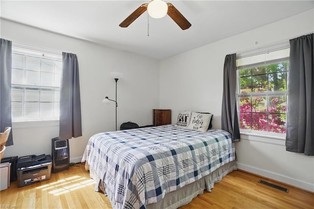 bedroom with visible vents, ceiling fan, wood finished floors, and baseboards
