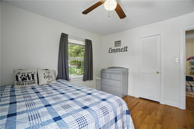 bedroom featuring wood finished floors, ceiling fan, and baseboards