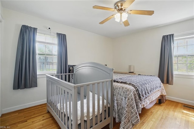 bedroom with visible vents, hardwood / wood-style flooring, and baseboards