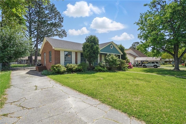 view of front facade with a front yard, driveway, and brick siding