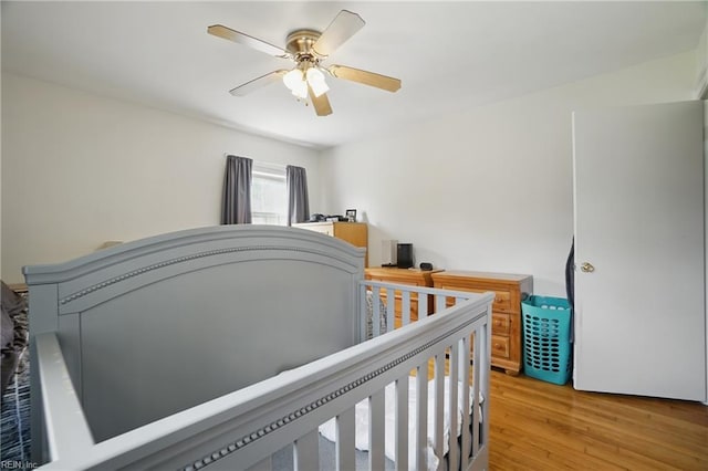 bedroom with a ceiling fan and light wood-style flooring