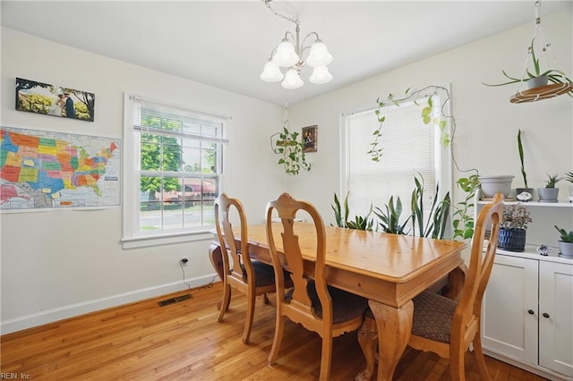 dining space featuring an inviting chandelier, baseboards, light wood-style floors, and visible vents