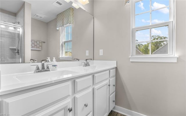 bathroom featuring visible vents, a sink, plenty of natural light, and a stall shower