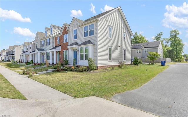 view of front of property featuring a residential view, fence, and a front yard
