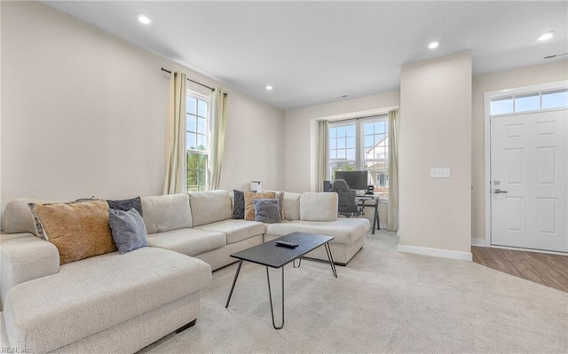 living area with baseboards, recessed lighting, and light colored carpet