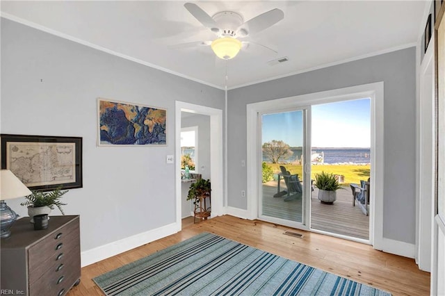 doorway to outside featuring visible vents, baseboards, crown molding, and ceiling fan