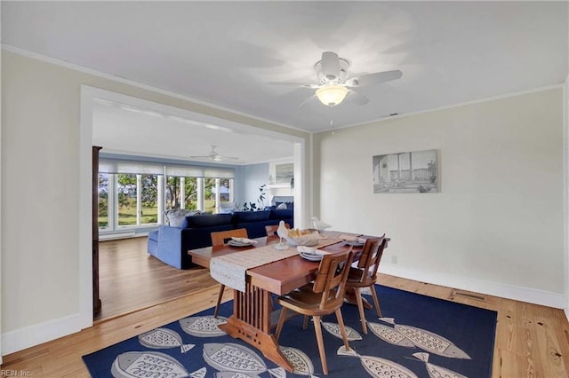 dining space featuring crown molding, visible vents, wood finished floors, baseboards, and a ceiling fan