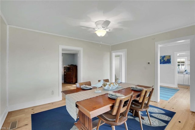 dining area with ornamental molding, a ceiling fan, light wood-style flooring, and visible vents