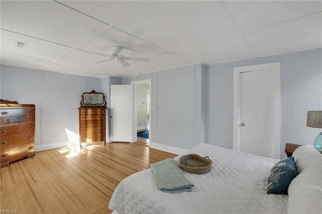 bedroom featuring ceiling fan, a paneled ceiling, visible vents, wood finished floors, and baseboards