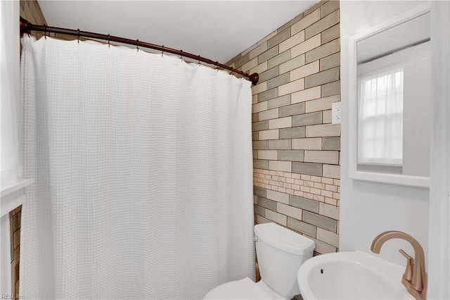 bathroom with a sink, tile walls, a shower with curtain, and toilet