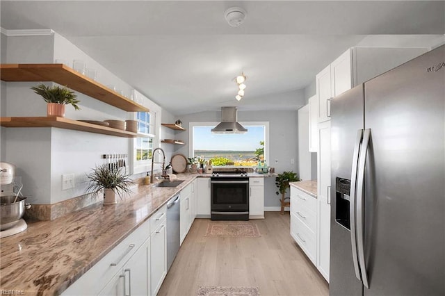 kitchen with wall chimney range hood, open shelves, a sink, light wood-style floors, and stainless steel appliances