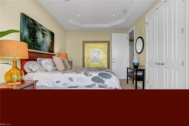 carpeted bedroom with a tray ceiling
