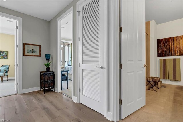 corridor with baseboards and light wood finished floors