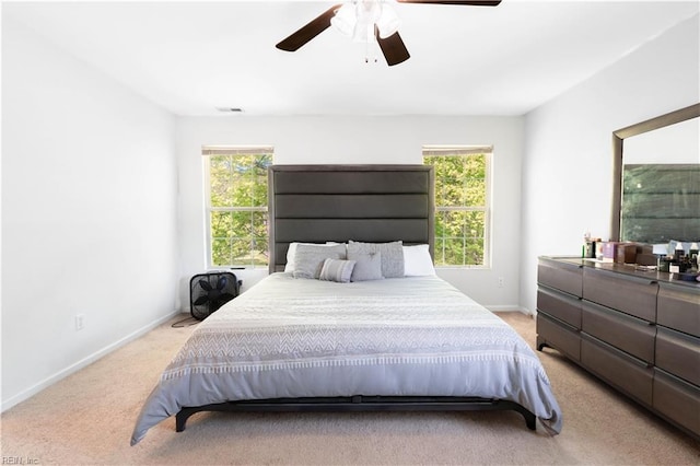 bedroom with light colored carpet, baseboards, and multiple windows