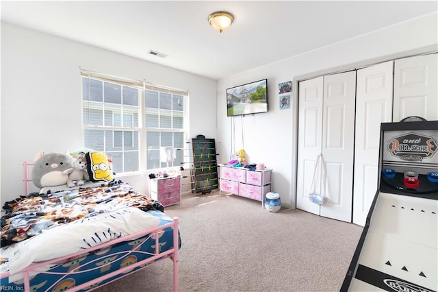 bedroom featuring carpet floors, visible vents, and a closet