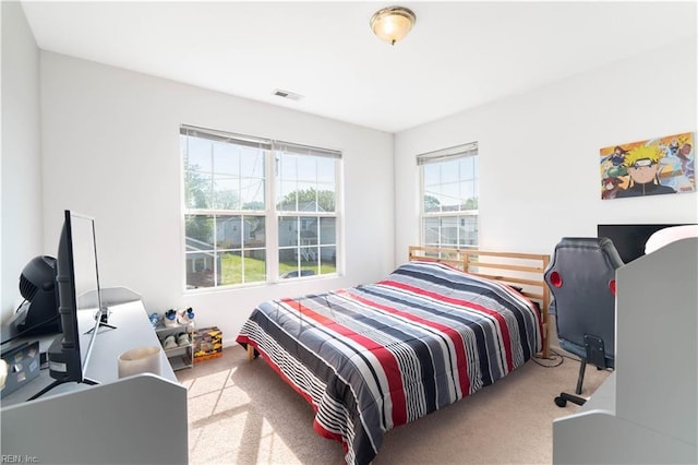 carpeted bedroom featuring visible vents