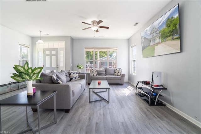 living room featuring baseboards, ceiling fan, wood finished floors, and visible vents