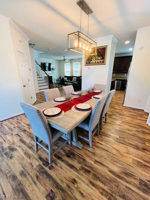dining area featuring crown molding, ceiling fan, stairs, recessed lighting, and wood finished floors
