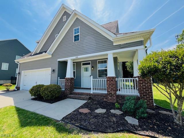 craftsman inspired home featuring an attached garage, brick siding, a front yard, concrete driveway, and covered porch