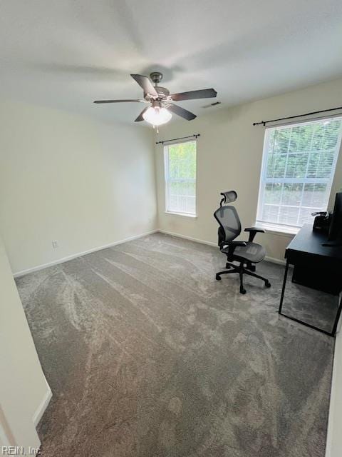 unfurnished office featuring baseboards, a ceiling fan, carpet flooring, and visible vents