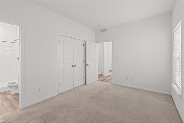 unfurnished bedroom featuring baseboards, carpet, and visible vents