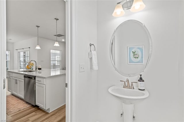 bathroom featuring visible vents, a sink, wood finished floors, and a notable chandelier