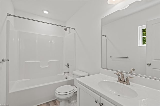 full bathroom featuring vanity, toilet, wood finished floors, and tub / shower combination