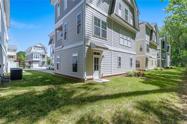 exterior space featuring a lawn, a residential view, and central AC unit