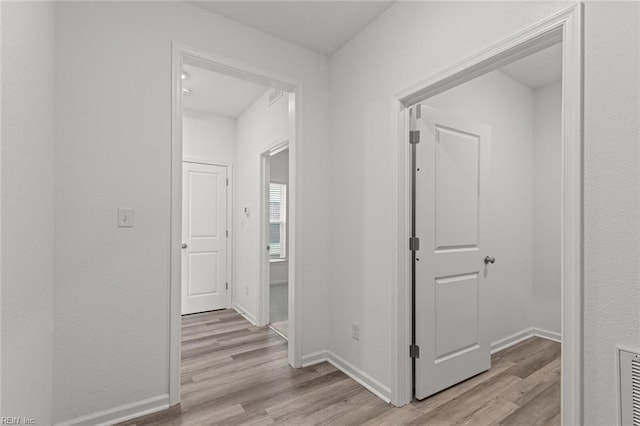 hallway featuring baseboards and light wood-type flooring
