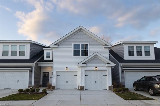townhome / multi-family property with driveway and an attached garage