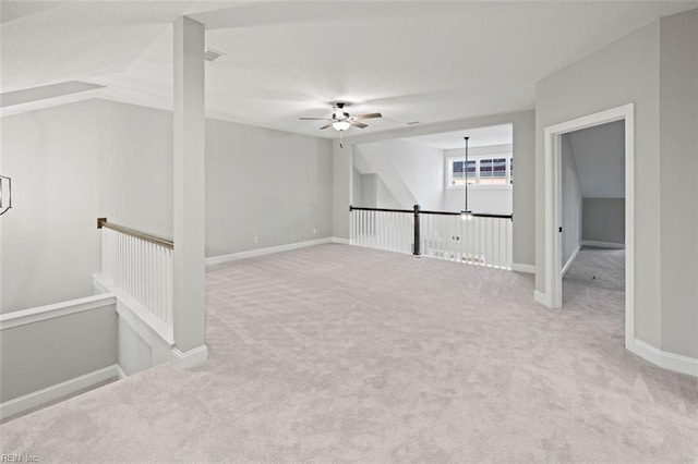 carpeted empty room featuring baseboards, visible vents, and ceiling fan