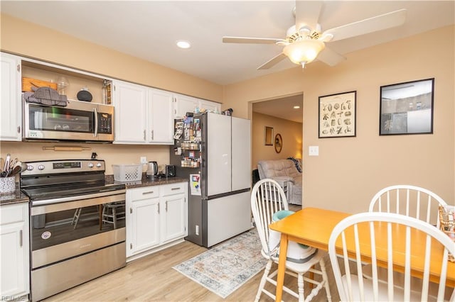 kitchen with appliances with stainless steel finishes, ceiling fan, light wood-style flooring, and white cabinetry