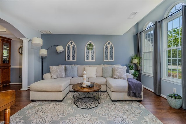 living area featuring visible vents, ornate columns, and wood finished floors
