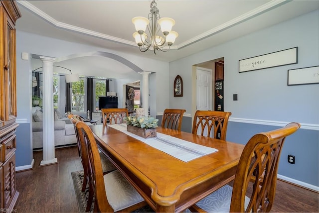 dining room featuring decorative columns, arched walkways, a raised ceiling, a chandelier, and dark wood-type flooring