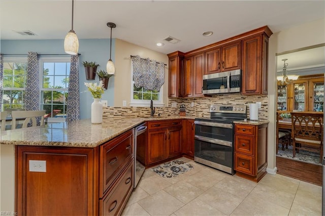 kitchen featuring light stone counters, backsplash, a healthy amount of sunlight, and stainless steel appliances