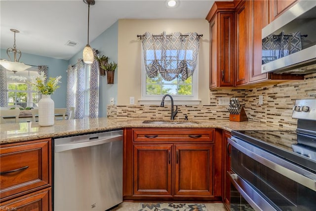 kitchen with backsplash, visible vents, a sink, light stone counters, and stainless steel appliances