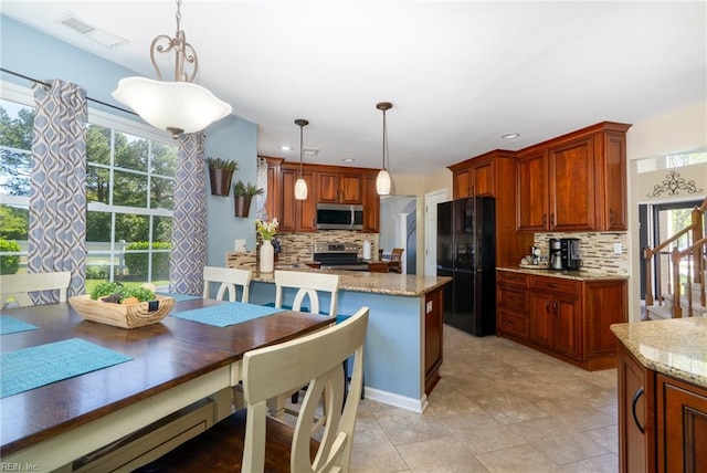 kitchen with stainless steel appliances, visible vents, decorative backsplash, and light stone counters
