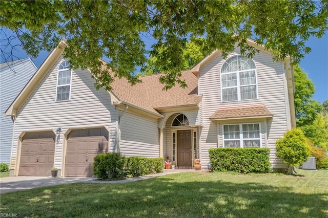 traditional-style home featuring a front lawn, a shingled roof, central AC unit, concrete driveway, and an attached garage