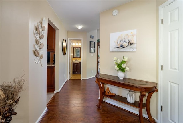 hallway featuring baseboards and dark wood finished floors