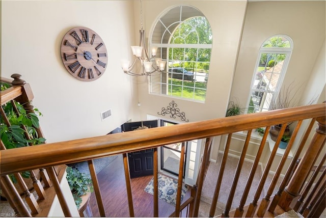 interior space featuring an inviting chandelier, wood finished floors, and visible vents