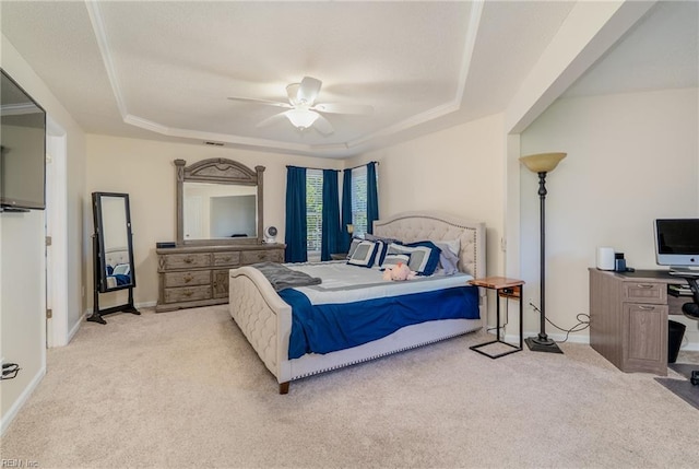 bedroom with a raised ceiling, ceiling fan, light carpet, and baseboards