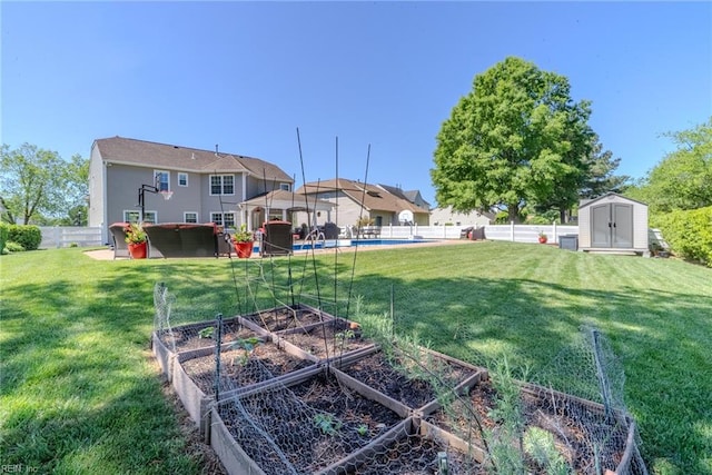 view of yard featuring a fenced backyard, an outbuilding, a vegetable garden, and a shed