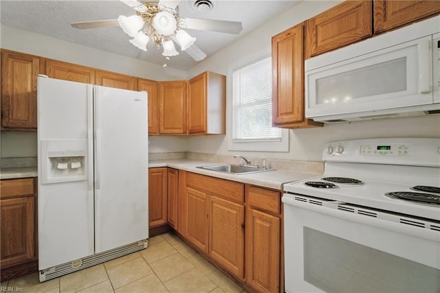 kitchen featuring light tile patterned flooring, ceiling fan, a sink, white appliances, and light countertops
