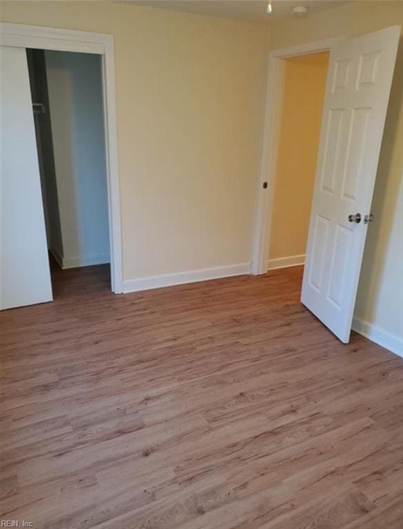 unfurnished room with baseboards and wood finished floors
