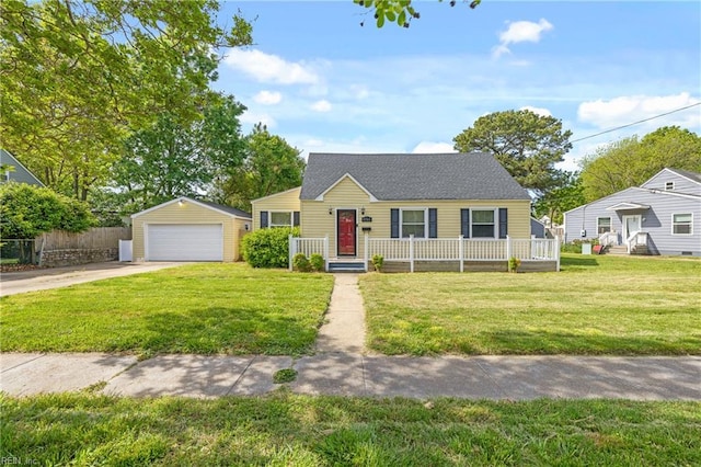 view of front of home featuring a detached garage, fence, an outbuilding, and a front lawn