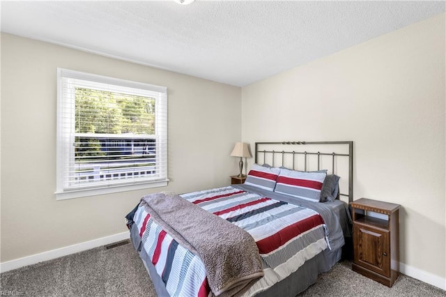 carpeted bedroom featuring a textured ceiling and baseboards