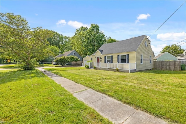 view of front of property featuring fence, a shingled roof, and a front yard