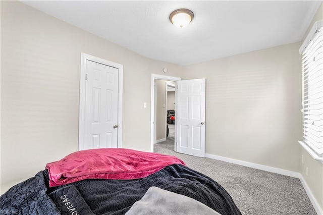 bedroom featuring light colored carpet and baseboards