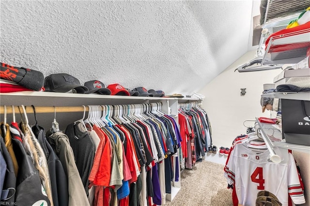walk in closet featuring carpet flooring and lofted ceiling